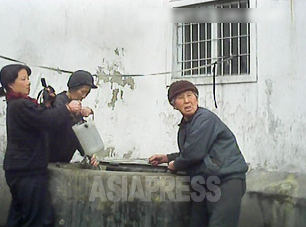 アパートの住民たちが専用井戸で水を汲んでいる。他の住民が利用出来ないように鉄製の蓋が設置されている。(2013年3月、平安南道平城市　ペク・ヒャン撮影)
