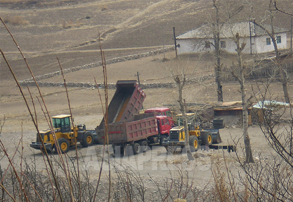 茂山郡には大型車両が数多く見える。鉄鉱石を中国に輸出して外貨を稼げるため、国営鉱山として国家経営がなりたっている。2009年4月中国側からアジアプレス撮影