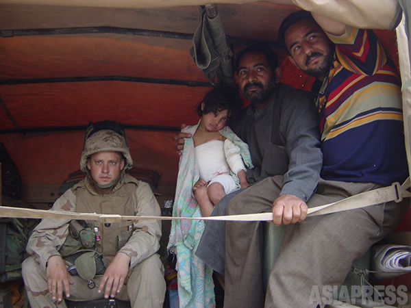 米軍トラックに載せられて運ばれるイラク人の女の子と家族 。2003年4月、バグダッド市内で 撮影綿井健陽(アジアプレス)