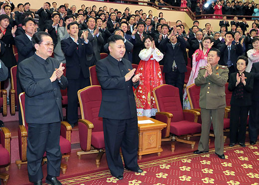 これも張と金正恩が「並び立つ」ことを印象付ける強烈な写真だ。右前列にいる金慶姫と崔龍海をはじめ会場の全員が、まるで二人を称えて拍手を送っているように見える。2013年4月15日の金日成生誕日に楽団の演奏観覧を伝える記事より。（労働新聞）より引用）