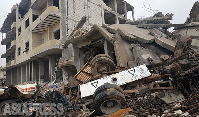 フェルハッドさん一家はシリア・コバニから脱出した。町はＩＳの総攻撃で瓦礫となった。写真はＩＳの自爆突撃で崩壊した建物。ＩＳは一時撤退したものの、近郊では現在も戦闘が続いている。農村地域も含め20万におよぶ住民がトルコに避難し難民となった。（コバニ市内で、玉本撮影：2014年12月）