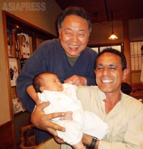 京都の先斗町のお店で、お客さんの赤ちゃんを抱かせてもらい、大喜びのワリードさん。イラクに家族を残し1年がたとうとしていた。（2012年6月：玉本撮影）