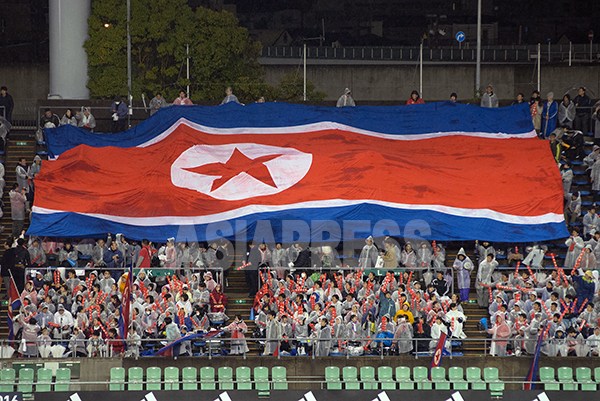 試合開始に先立ち、北朝鮮応援団が大型北朝鮮国旗を掲げている。