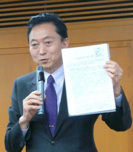 大阪市で講演する鳩山元首相。普天間「県外移設」を断念するきっかけとなった問題の文書のコピーを手に語る鳩山さん（撮影・栗原佳子）