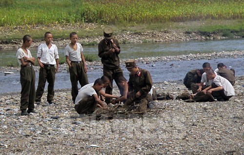 痩せこけた兵士たちが、盗んで来たトウモロコシを食べるため火の準備をしている。朝鮮人民軍には栄養失調が蔓延。2008年8月平壌郊外でチャン・ジョンギル撮影（アジアプレス）