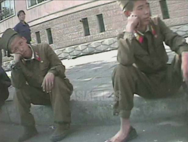 部隊の移動の合間、駅前広場で脱力したように座り込む若い兵士。2008年10月沙里院市で撮影シム・ウィチョン（アジアプレス）