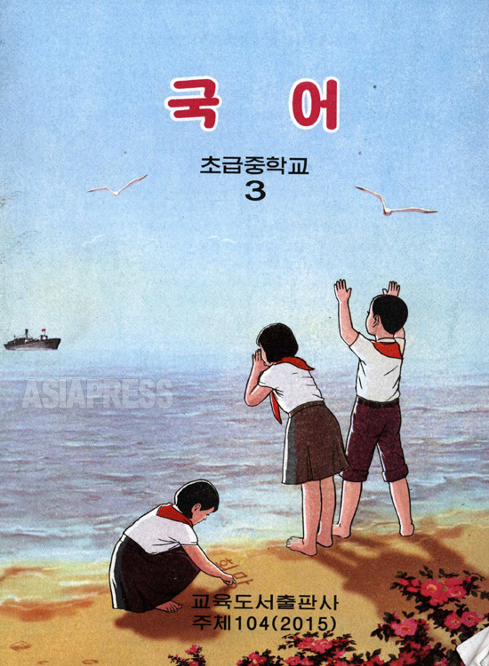 素朴なイラストが愛らしい初級中学3年用の国語の教科書。砂浜に女子生徒が「希望」と書いている。（アジアブレス）