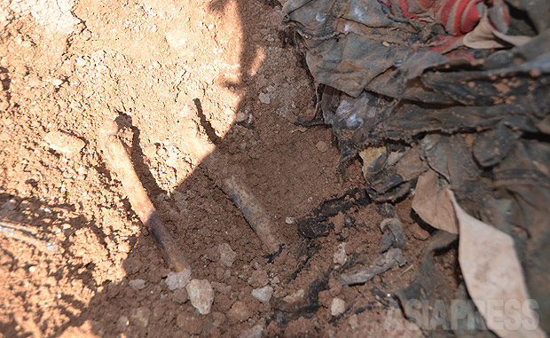 土を掻き分けると、人骨が出てきた。今も周辺にはISがいるため、調査や埋葬作業もできないままだった。現場を訪れていた住民たちは墓をつくってやれないことを悔やんでいた。（2016年3月撮影・玉本英子）