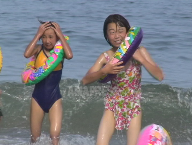 着慣れないのだろうか、水着はぶかぶか。2000年以降、浮輪や水着は中国から大量に入るようになった。2006年7月(アジアプレス)