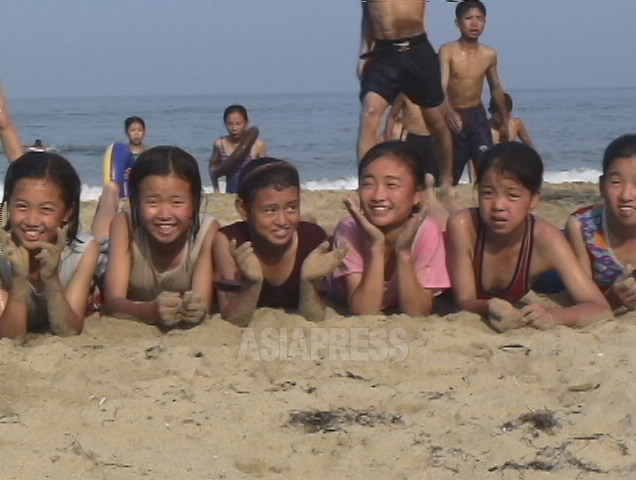 女子たちの弾けそうな笑顔にはほっとさせられる。実に楽しそうな海水浴。2006年7月(アジアプレス)