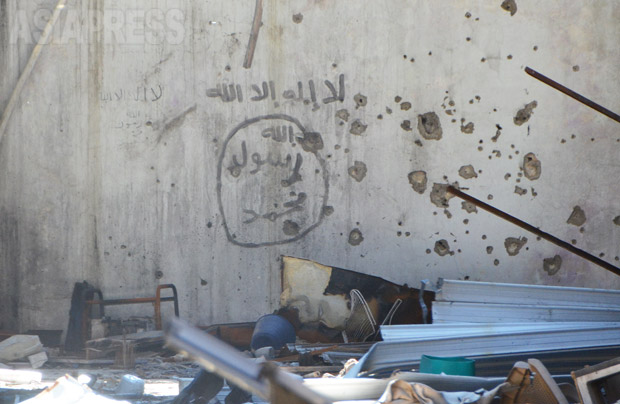 破壊されたIS司令部の中。壁にはたくさんの銃弾の痕とともに、ISが残したペイントやスローガンが残されていた。写真はISの黒い旗と同じ、「アッラーの他に神はなし・ムハンマドはアッラーの使徒なり」の文字。同行したペシュメルガ兵は「ISはイスラムじゃない」と話した。（2016年3月・撮影・玉本英子）