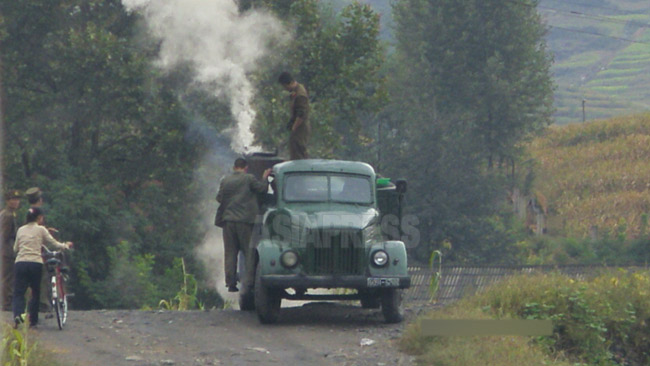 エンコした木炭車を修理する兵士たち。木炭車は相当な数が現在も軍の輸送車両として使われている。2008年8月平壌市郊外にて撮影チャン・ジョンギル(アジアプレス)