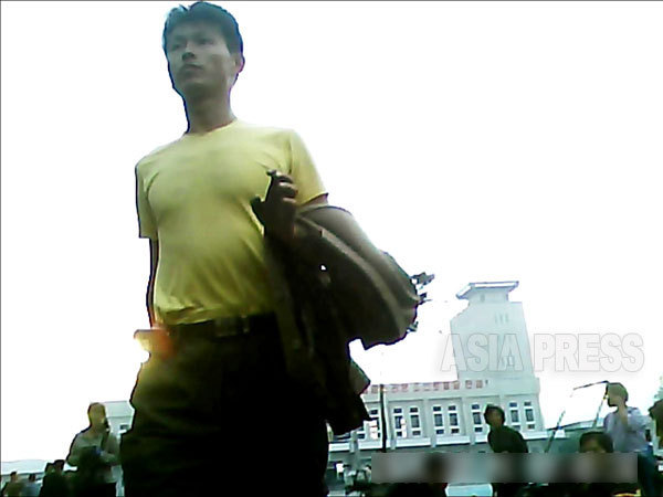がっしりした体躯がシャツに写る。中部地域の平安南道平城（ピョンソン）市の駅前にて。2013年9月撮影「ミンドゥルレ」（アジアプレス）
