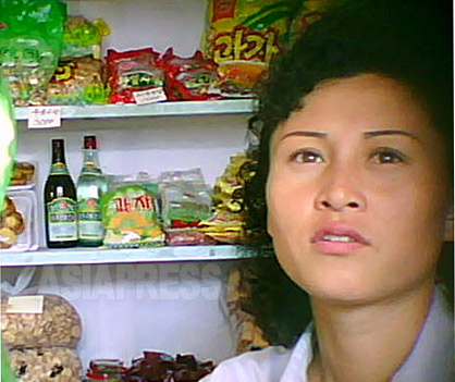化粧をしっかり整えて、協同組合式の商店で菓子やパンなどを売る女性。2011年9月平壌市にて撮影ク・グァンホ（アジアプレス） 