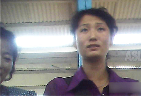 市場の日用品売り場で愛想よく客迎える女性。幅80センチの売り場の経営者である。 2013年8月両江道の恵山市場にて　撮影アジアプレス