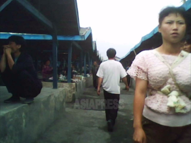 市場に買い物に来たおんぶひもを使う女性。2010年6月平安南道にて撮影キム・ドンチョル（アジアプレス）