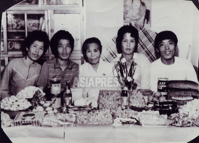 福岡出身の金綾子さん（右から二人目）ら姉弟が母親（中央）の古稀を祝っている。1993年頃か。ご馳走が並んでいるが皆痩せている。（アジアプレス）