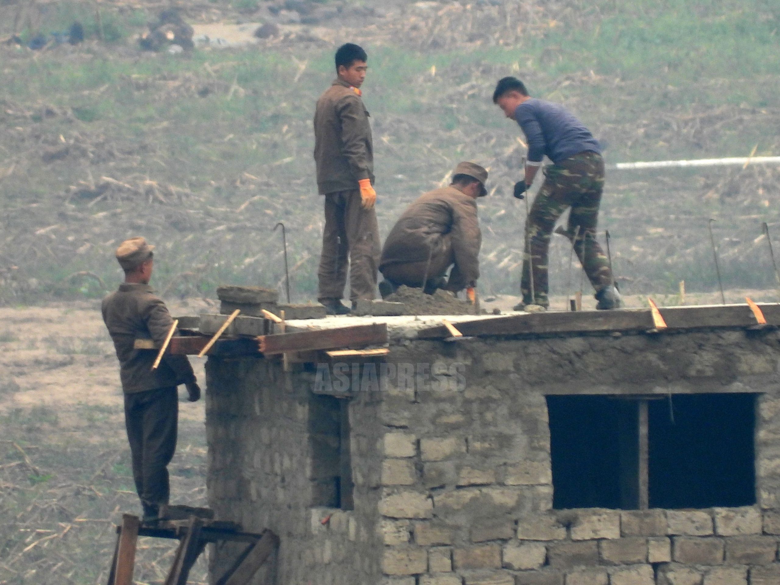 超望遠レンズ撮影＞北朝鮮の水害復旧現場は今（3） 土砂降りのなのに