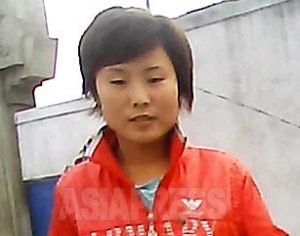 진홍색 잠바가 눈길을 끄는 여성. 북한에서 유통되는 대부분의 의류는 중국산. 외부의 문화가 수입품을 통해 확산되고 있다. 2013년 9월 함경북도 청진시에서 촬영 아시아프레스.