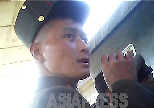  담배를 손에 든 채 열차에 탑승하려 하는 군인. 2013년 10월 양강도 혜산 역에서 촬영 '민들레'(아시아프레스)
