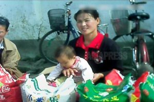 아기를 안은 여성이 팔고 있는 것은 중국산 백미. 2013년 10월 양강도에서 촬영 '민들레'(아시아프레스)