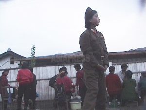 구깃구깃한 군복을 입은 젊은 여병사가 시장 변두리의 노천 식당 옆을 서성이고 있었다. 2004년 4월 함경북도에서 촬영 안 철(아시아프레스)