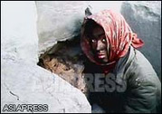 A soot-blackened Kotchebi,or homeless whose age is 19, tries to have a warm by the building's floor heating. (January. 2011. North Pyongan Province, by KimDong-cheol) (C)ASIAPRESS 