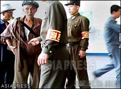 An old man was stopped by soldiers. He got raked over for his shabby-looking clothes. The soldier's armband reads "inspection". (Taken by Gu Gwang-ho) (C) ASIAPRESS