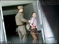 A soldier took the arm of a woman with a backpack, and forcibly took her out when she tried to slither past the inspection. (Taken by Gu Gwang-ho) (C) ASIAPRESS