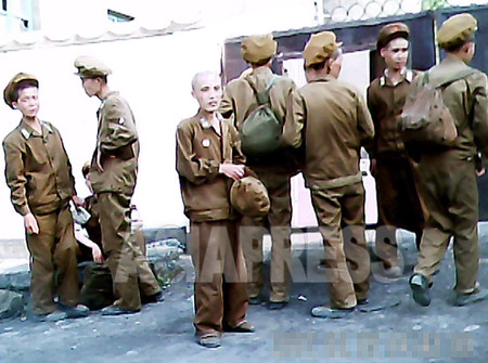 A group of young soldiers who are going to be transferred to the rear-echelon because of malnourishment. Some skinny soldiers stagger and can hardly walk. The troop commander told them to stay behind the wall so as not to be seen by the public. (Taken by Gu Gwang-ho, July, 2011. South Pyongan Province) ASIAPRESS