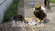 The emaciated young soldier squatting here is collecting pieces of stolen corn from a cooperative farm. (September 2008, by Chang Jeong-gil)