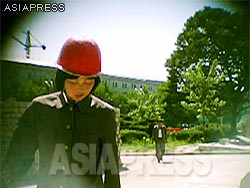 Numerous young students are mobilized to work at construction sites, but because they are unfamiliar with the work, more than a few are injured. This young woman wearing a helmet is a mobilized member of theYouth League Shock Troops which is usually deployed to the state -level construction projects.(Aug/2011/Taken by Gu Gwang-ho)