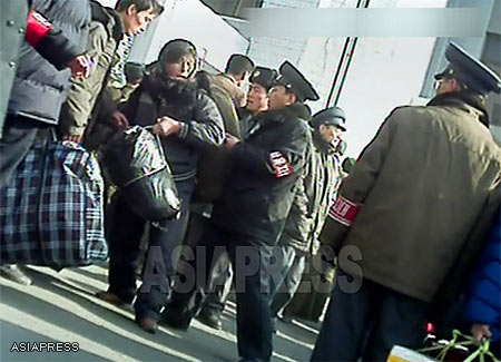 In front of the Sinuiju railway station people carrying large bags into the station are being stopped and searched by the officers of the Public Order Maintenance Corps (질서유지대), on the lookout for illicit materials being distributed within the country. Sinuiju City, North Pyongan Provice. ( November 2012, Taken by Rimjin-gang's reporting partner in North Korea)　ASIAPRESS