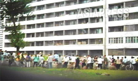 Apartment buildings in Rakrang, the south-west district of Pyongyang. In the narrow street next to the apartment people gather around to buy and sell various items. (Photo taken by Lee Jun, 2007, August)　ASIAPRESS