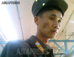 A commissioned officer shopping at the marketplace. His rank, as shown on his lapel, is lieutenant. It can be easily recognized from his cheeks that his is in a state of emaciation.