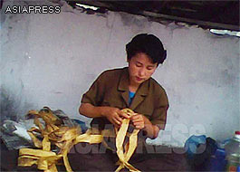 A stall keeper is coiling the half-dried belts of "artificial meat" at the public market. (South Pyongan Province. June, 2010. Taken by Kim Dong-cheol) ASIAPRESS