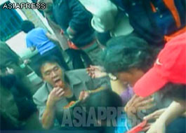 A man is eating the "artificial meat rice pouch" at a street stall. Rice stuffed into the pouch of "artificial meat", which is flavored with red pepper or vinegar. The taste and texture is considered favorable. (Kowon, South Hamkyung Province. August 2012) ASIAPRESS