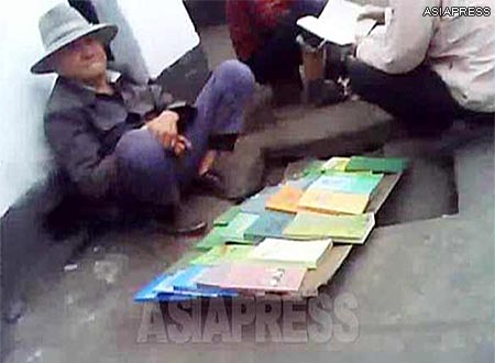 Some textbooks sold by the roadside street-vendor: "Secret of the mind", "Exercise book (Q&A) on cerebral thrombosis", "Some ideas for teaching singing and dancing", and "Economic contracts" can be seen in this picture. (Taken in a northern border town of North Korea.) ASIAPRESS