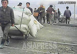 A man is pulling a fully loaded handcart across the railway tracks. (Pyongsong. South Pyongan Province. March, 2013)ASIAPRESS