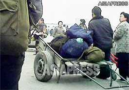 A female customer (right) negotiates with the porter (left) on the price for his services (Pyongsong. South Pyongan Province. March, 2013) ASIAPRESS