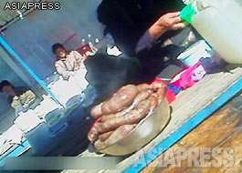 A Korean sausage called sundae is laid on the counter of the butcher's stall. The white tankard next to the sundae is liqueur, as it is customary to consume sundae with alcohol. The alcohol is sold by the cup. ASIAPRESS