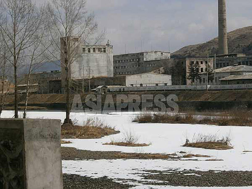 The frozen border river, Arok-gang (Yalu River). The factory complex on the opposite side of Hyesan river appears not to be operating, as there is no smoke emerging from the chimney. (Photo taken from the Chinese side of the border. March.2014) ASIAPRESS