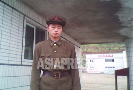 A member of the "Worker-Peasant Red Guards" stands in front of the entrance to a state run enterprise. (Taken by Kim Dong-cheol, South Pyongan Province, October 2010.) . ASIAPRESS